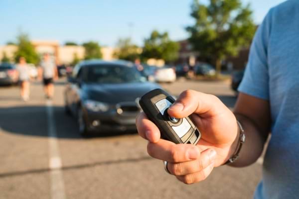 main d'une personne tenant une cl&eacute; de voiture moderne.