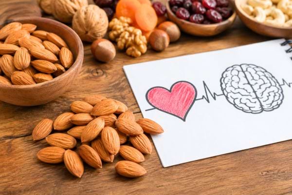 bol d'amandes à côté de fruits et d'un dessin de coeur er de cerveau : bienfaits