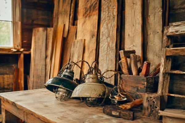 vintage light fixtures, and second-hand tools resting on a workbench in a garage.