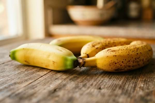 deux bananes côte à côte : l'une jaune clair avec des pointes vertes, l'autre jaune foncé