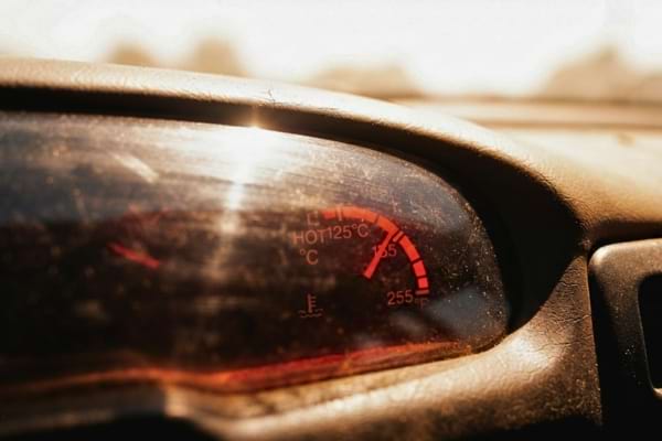 un thermomètre de tableau de bord de voiture affichant une température extrême dans le rouge