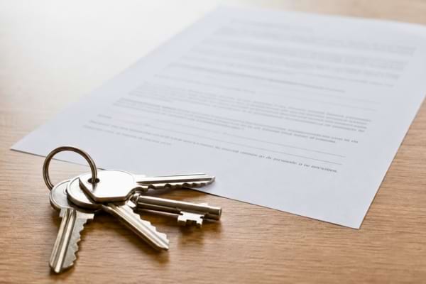 fausses clés d'appartement posées sur un faux contrat de bail