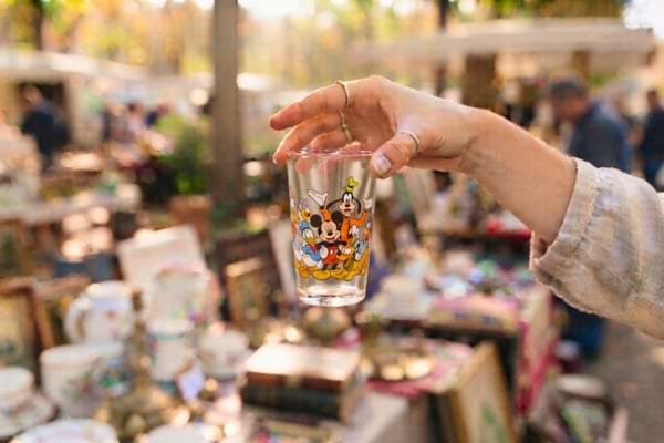 Une main tenant délicatement un verre à moutarde vintage