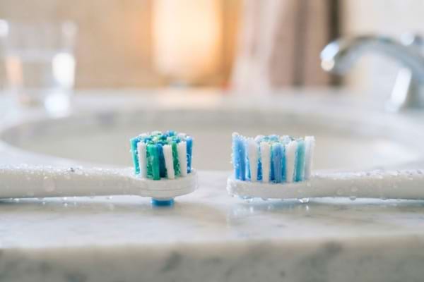 deux t&ecirc;tes de brosses &agrave; dents &eacute;lectriques, l'une ronde et l'autre de forme allong&eacute;e