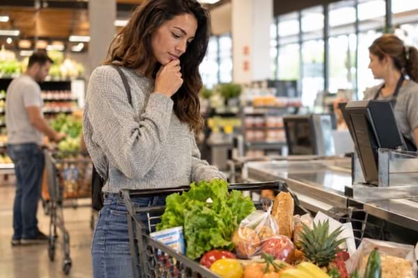 Cliente vérifiant son panier avant de passer à la caisse du supermarché.