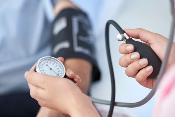 Professionnelle de santé mesurant la tension artérielle d’un patient.