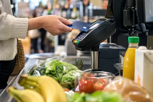 Paiement des courses par carte bancaire à la caisse d’un supermarché.