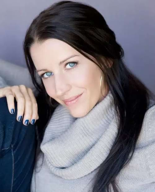portrait de Pattie Malette, mère de Justin Bieber, souriante, cheveux, en pull avec du vernis bleu
