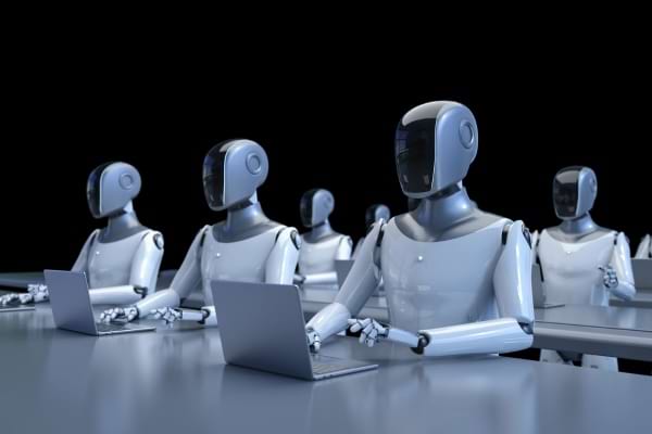 une image qui montre des robots à l'allure humaine devant des ordinateurs sur fond noir