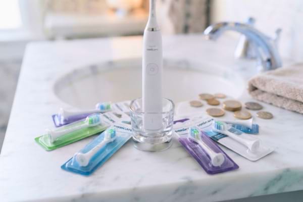  un manche de brosse &agrave; dents &eacute;lectrique entour&eacute; de plusieurs t&ecirc;tes de rechange neuves 