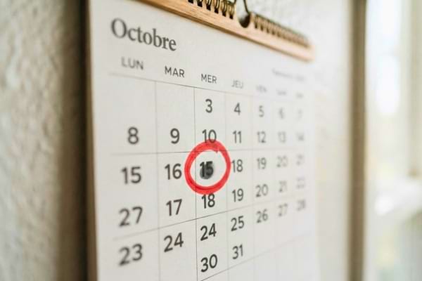 un calendrier mural de type familial. Une date spécifique est entourée d'un cercle rouge