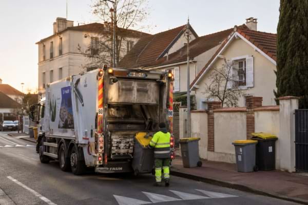 n camion poubelle moderne en pleine collecte dans un quartier résidentiel