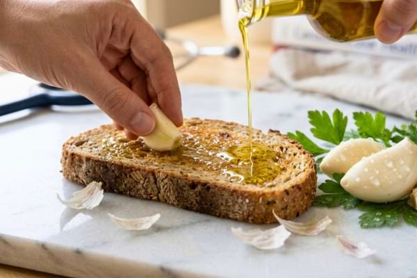une tranche de pain de campagne complet légèrement grillée sur laquelle on frotte une demi-gousse d'ail