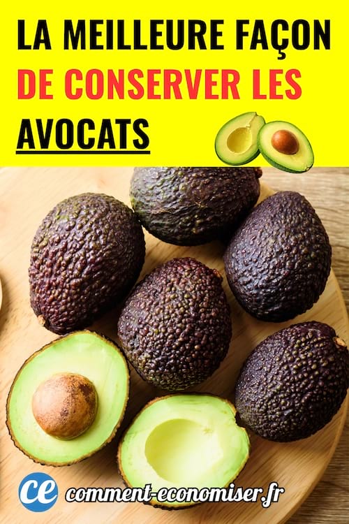 des avocats entiers et un avocat mûr ouvert posés sur une planche en bois ronde sur un plan de travail