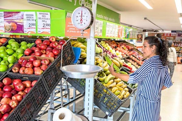 femme qui p&egrave;se des pommes au supermarch&eacute;