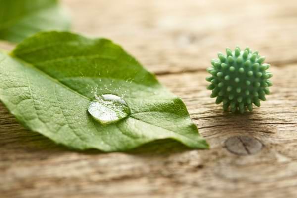 une goutte d'eau pure tombant sur une feuille verte, avec une balle de lavage