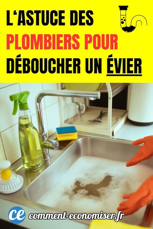 un évier en inox bouché dans une cuisine avec les mains d'une personne avec des gants de ménage