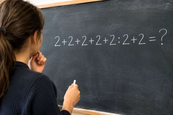 femme qui r&eacute;fl&eacute;chit devant un calcul de maths assez simple