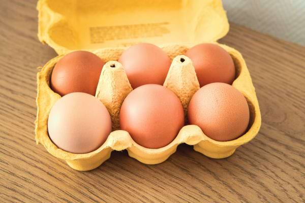 boîte de carton jaune avec 6 oeufs dedans