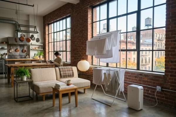 Un étendoir rempli de linge clair est placé intelligemment près d'une fenêtre légèrement entrouverte.