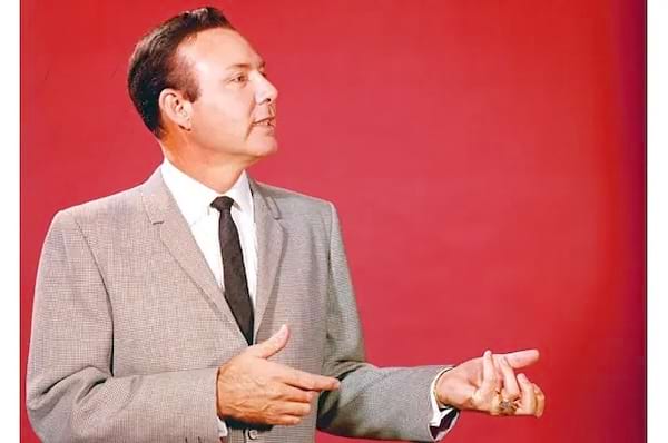 portrait de jim Reeves en costume cravate sur fond rouge imitant un jeu à la guitare