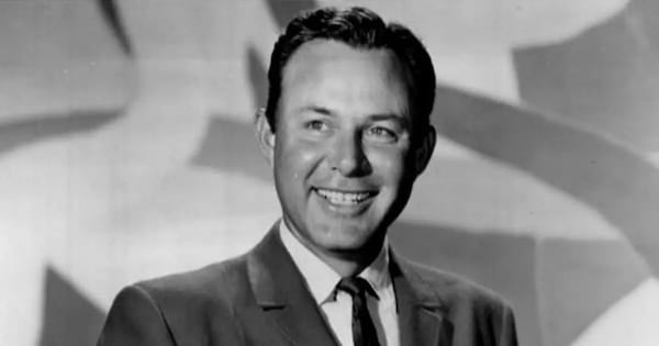 portrait noir et blanc de Jim Reeves souriant en costume cravate