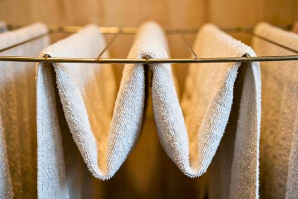 draps de bain propres suspendus en forme de zig-zag (en "W") sur les fils métalliques d'un étendoir.