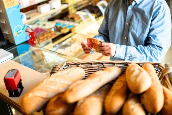 homme qui paye son pain en boulangerie avec un billet de 10€
