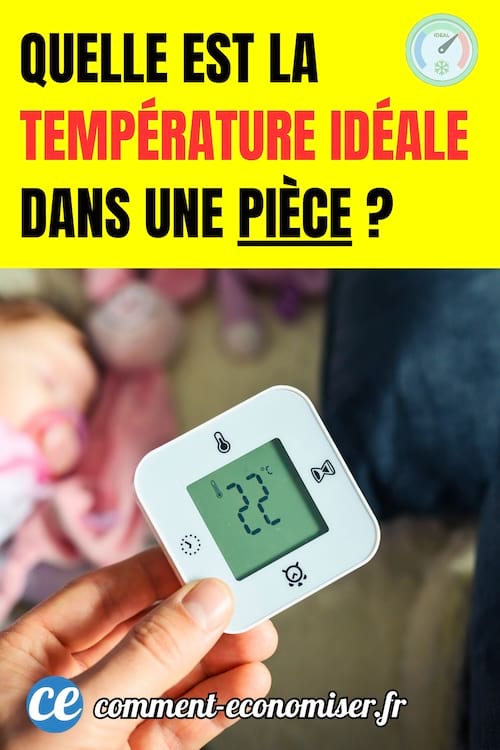 une main tient un thermostat à 22°C dans la chambre d'un bébé