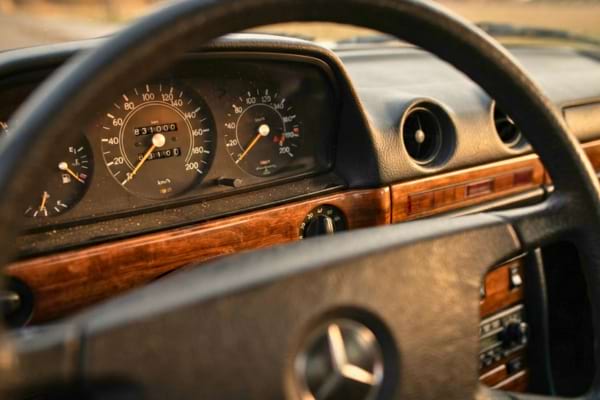 tableau de bord vintage d'une Mercedes des années 80. Le compteur kilométrique à rouleaux affiche le chiffre 831000