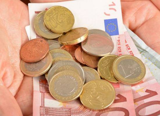 Pièces et billets en euro dans la main