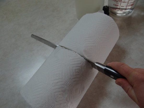 So schneiden Sie Ihre Papierhandtuchrolle in zwei Hälften.