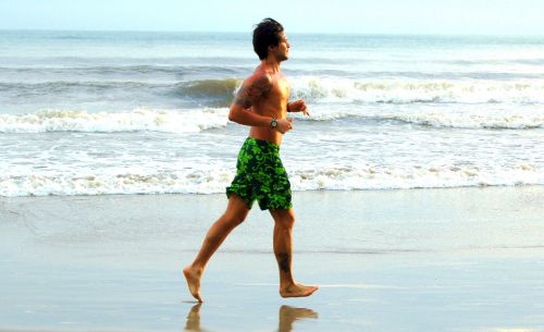 Jeune homme qui cours sur la plage