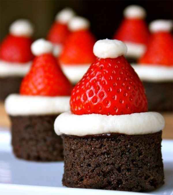 Morangos com chantilly colocados em bolos de chocolate como chapéus de Papai Noel