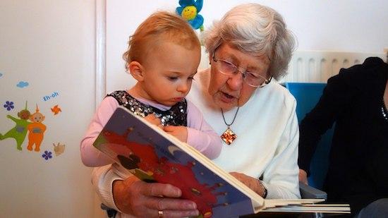 une grand-mère et son petit fils lisent un livre