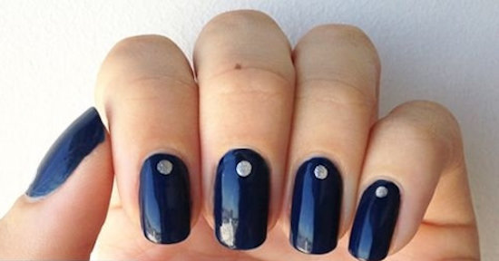 manucure minimaliste avec un point bleu