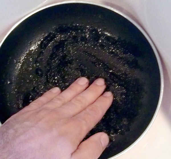 Clean a burnt pan with coffee grounds 