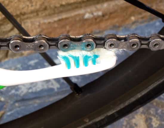 nettoyer la chaîne du vélo avec une brosse à dents