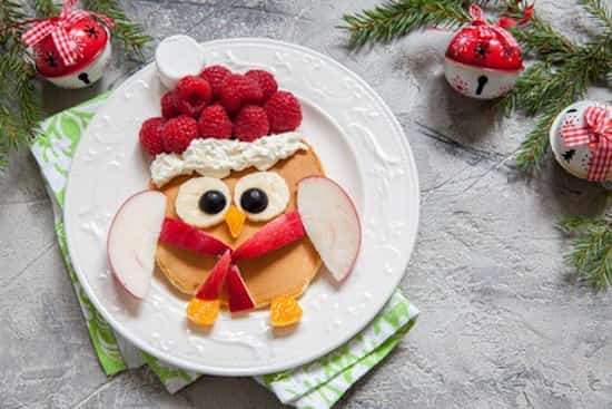 un petit oiseau pour le petit déjeuner fait avec des pancakes et des fruits