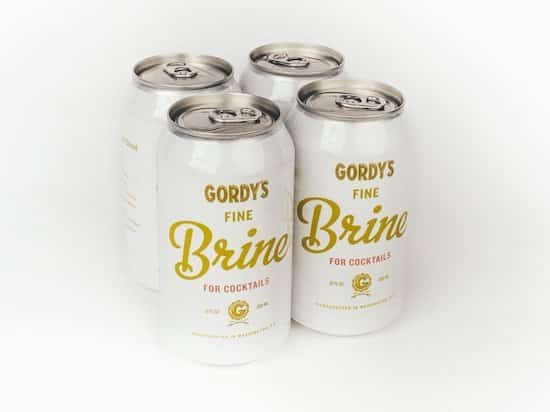 Voici 4 canettes de jus de cornichons Fine Brine.