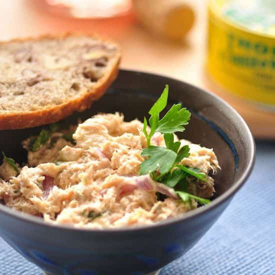 Des rillettes de thon dans un bol noir avec du pain
