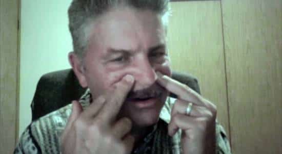 Un homme qui appuie sur les points d'acupression St3 pour soulager les douleurs de sinus associées au rhume.