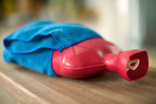 Une bouillotte en caoutchouc avec des tissu bleu et doux.