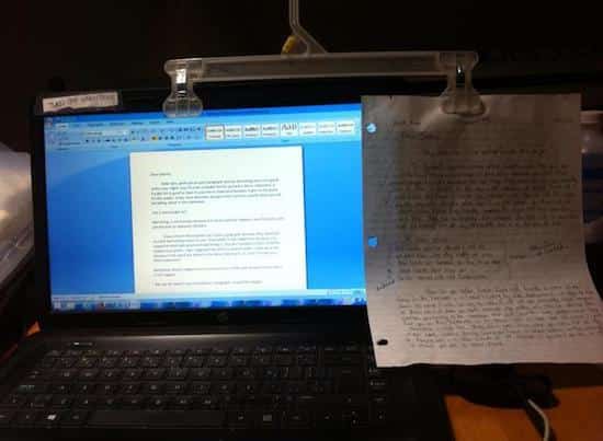 un cintre tenant une feuille à coté d'un ordinateur portable servant de brouillon