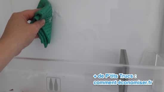 Nettoyage de frigo avec un chiffon vert 