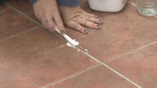 nettoyer et gratter les joints du carrelage avec une brosse à dents