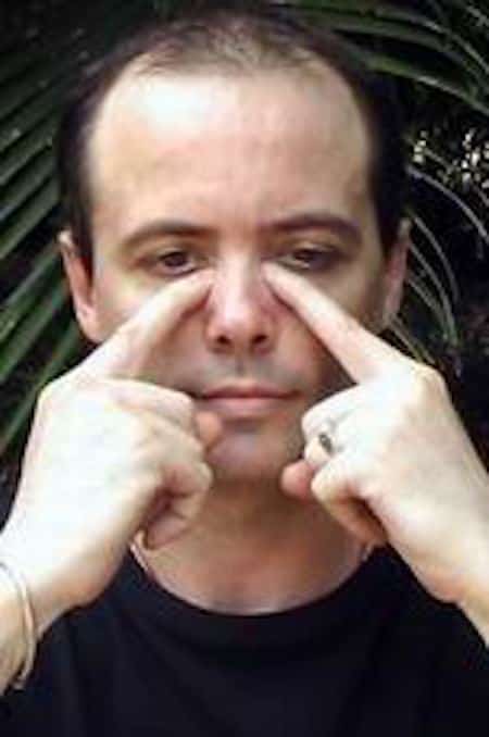 Homme qui exerce une pression sur les points d'acupression des sinus.