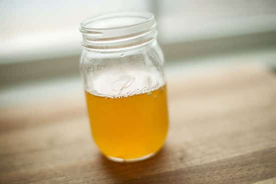 Bocal de sirop maison contre la toux sur une table de bois.