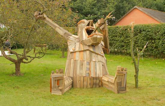 sculpture d'un géant en bois dévorant un arbre