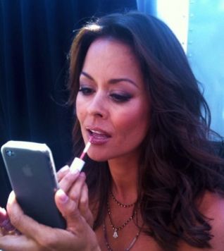 Femme qui se maquille avec la camera frontale de l'iphone